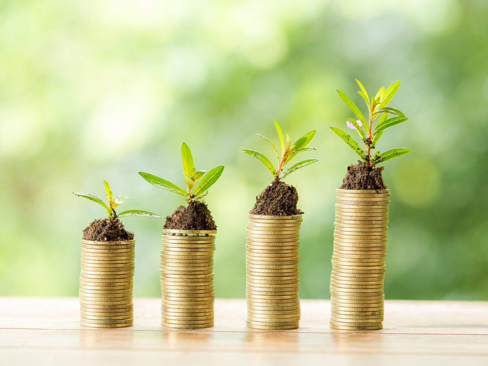 Coin on wooden table in front of green bokeh background. Coin on wooden table in front of green bokeh background. coins a concept of investment and saving moneys.